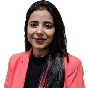 Woman in a coral blazer and black top, smiling against a white background.