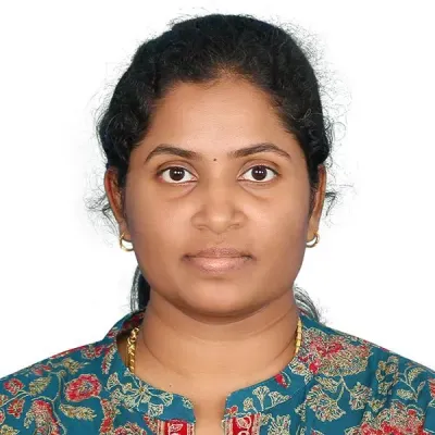 Portrait of a woman with dark hair wearing a patterned teal top against a white background