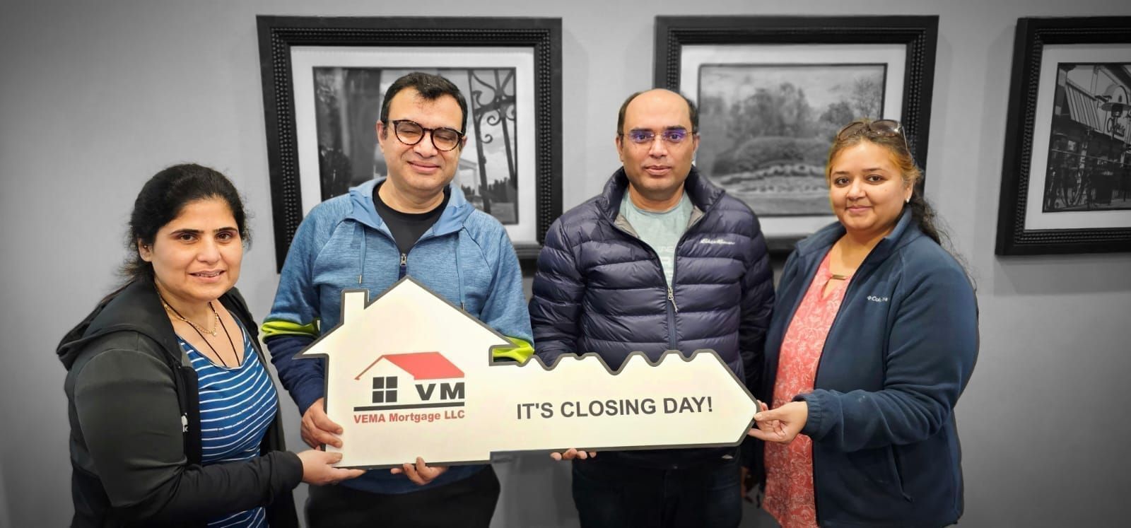 Four people in an office hold a sign with the JVM logo and “IT IS CLOSING DATE” text.