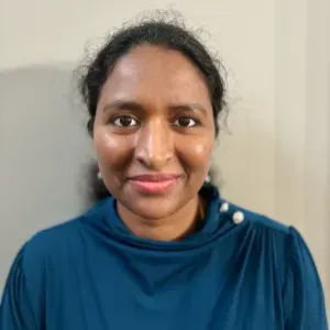 Portrait of a person smiling in a blue top against a light background