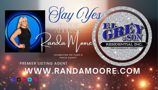 Real estate agent Randa Moore's business card. Blonde woman in black dress, name, website, company logo, and tagline.