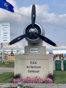 Black propeller monument marked “2024 EAA AirVenture Oshkosh” at an airshow entrance