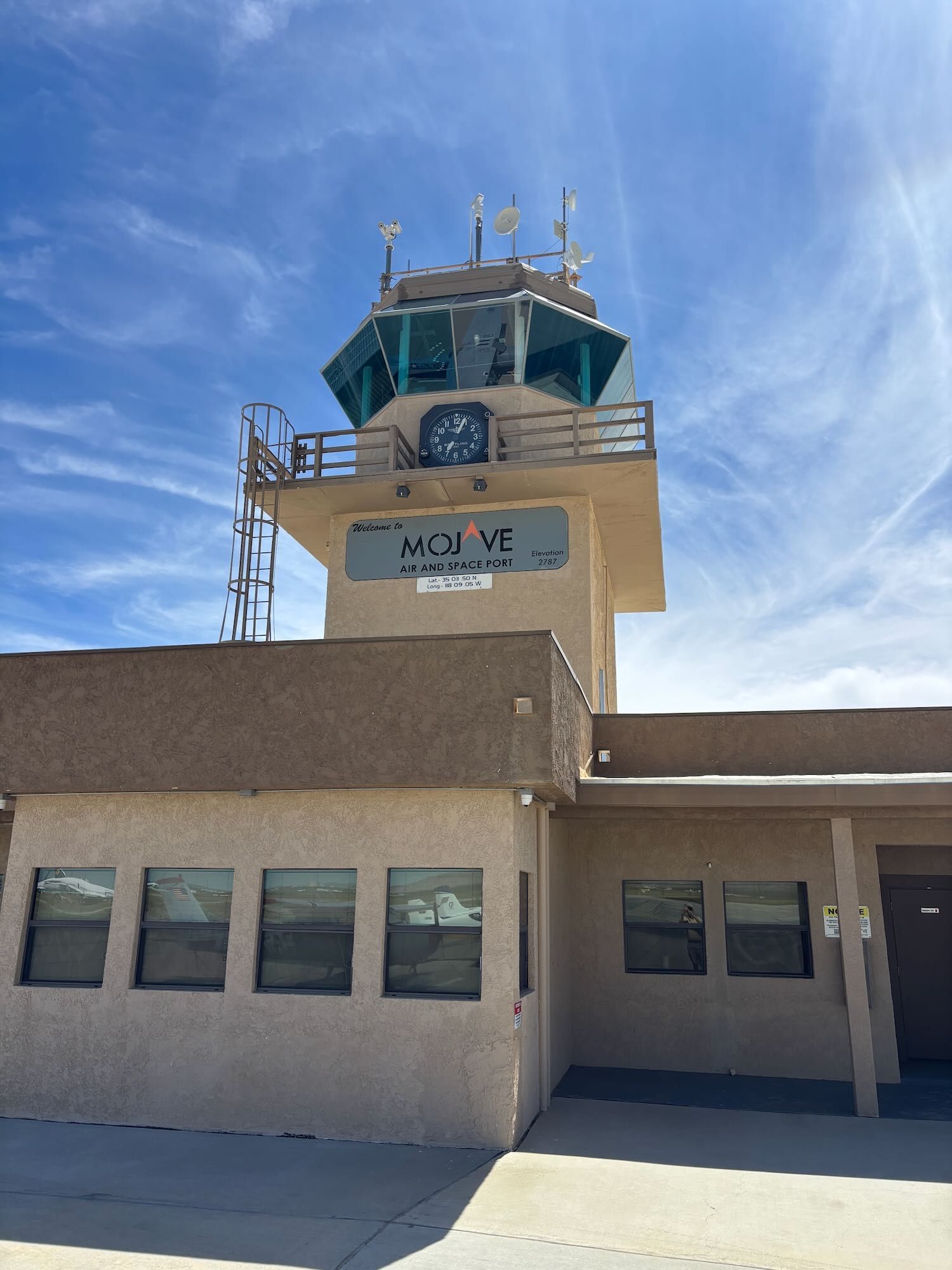 Airport control tower with beige building under a blue sky