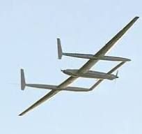 Two white sailplanes flying closely together against a blue sky