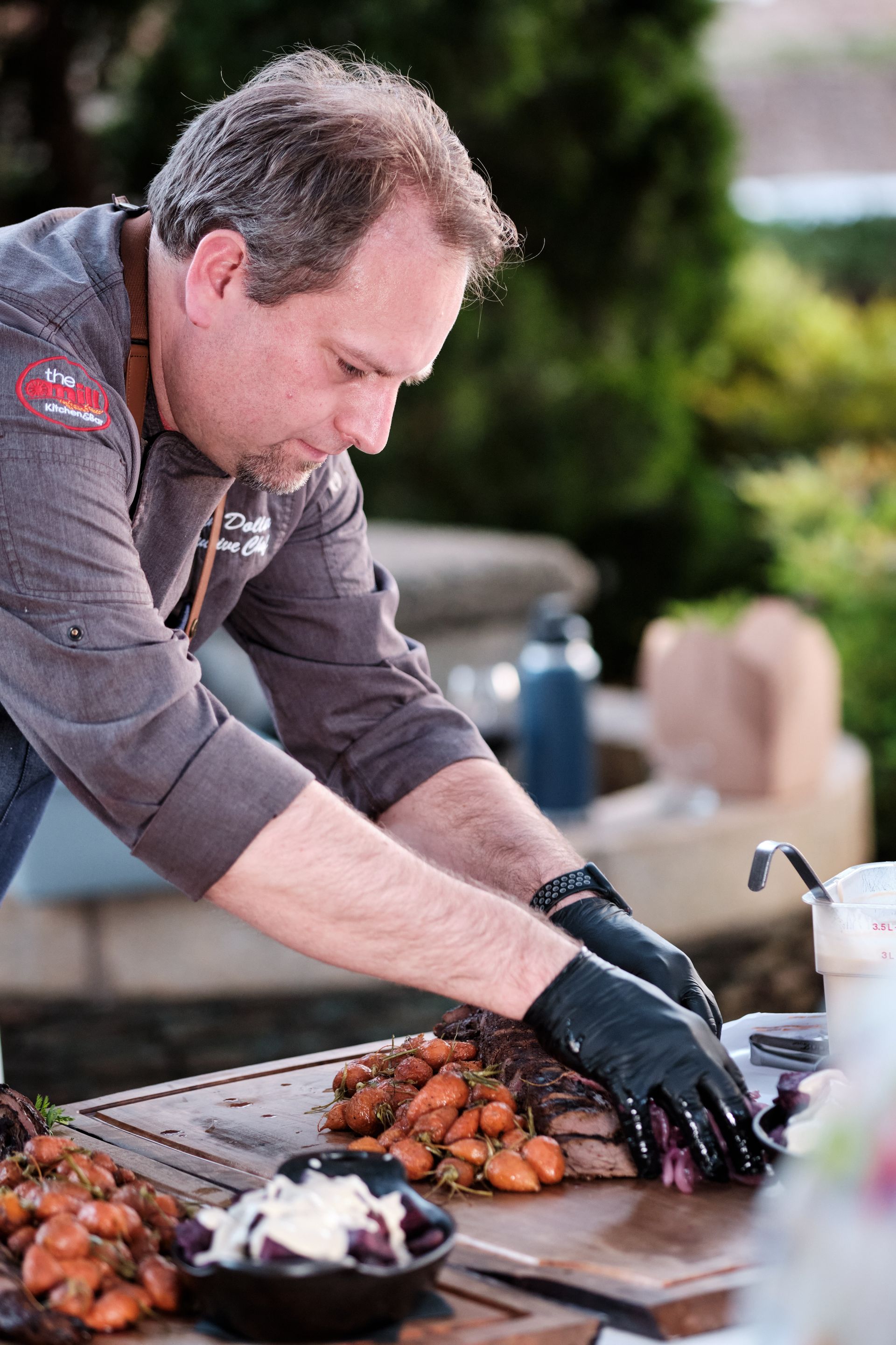 Chef cutting meat at the Mill Kitchen & Bar
