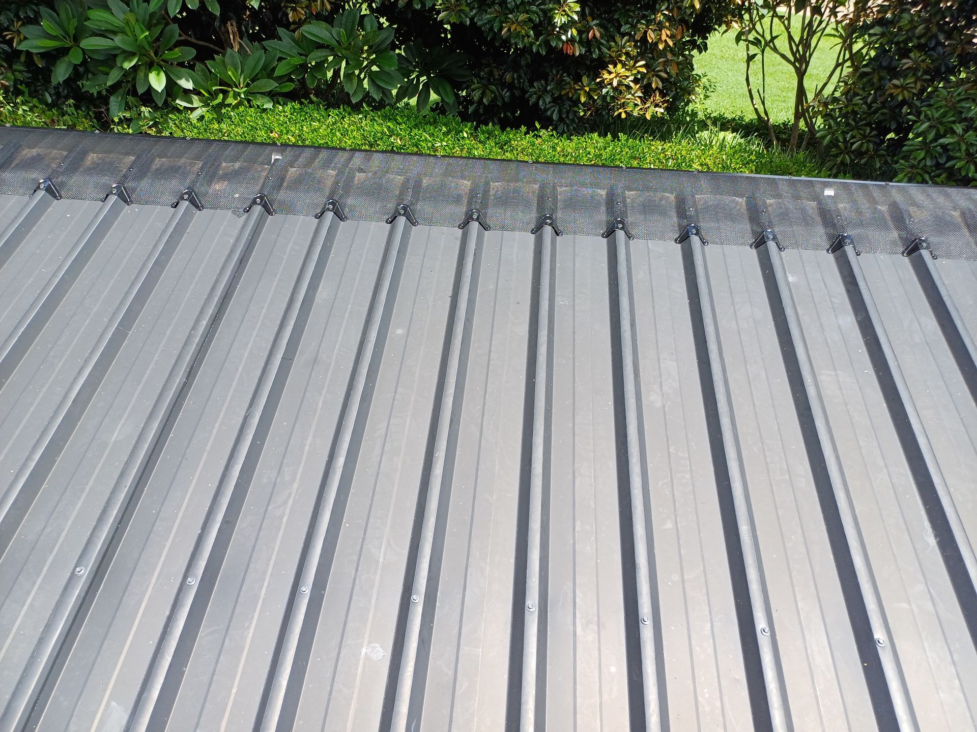 A Couple of Men Are Working on A Red Roof — Rooftech Roofing Services in Northern Rivers, NSW