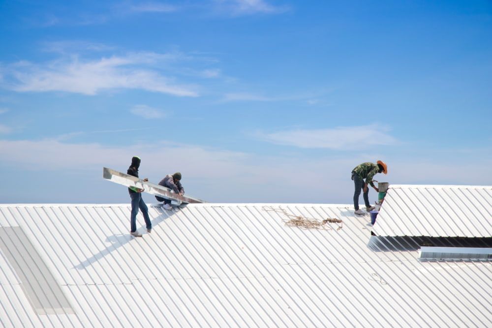 Three Men Are Working on A White Roof — Rooftech Roofing Services in Ocean Shores, NSW