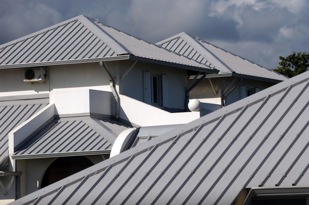 A White House with A Gray Metal Roof — Rooftech Roofing Services in Casino, NSW