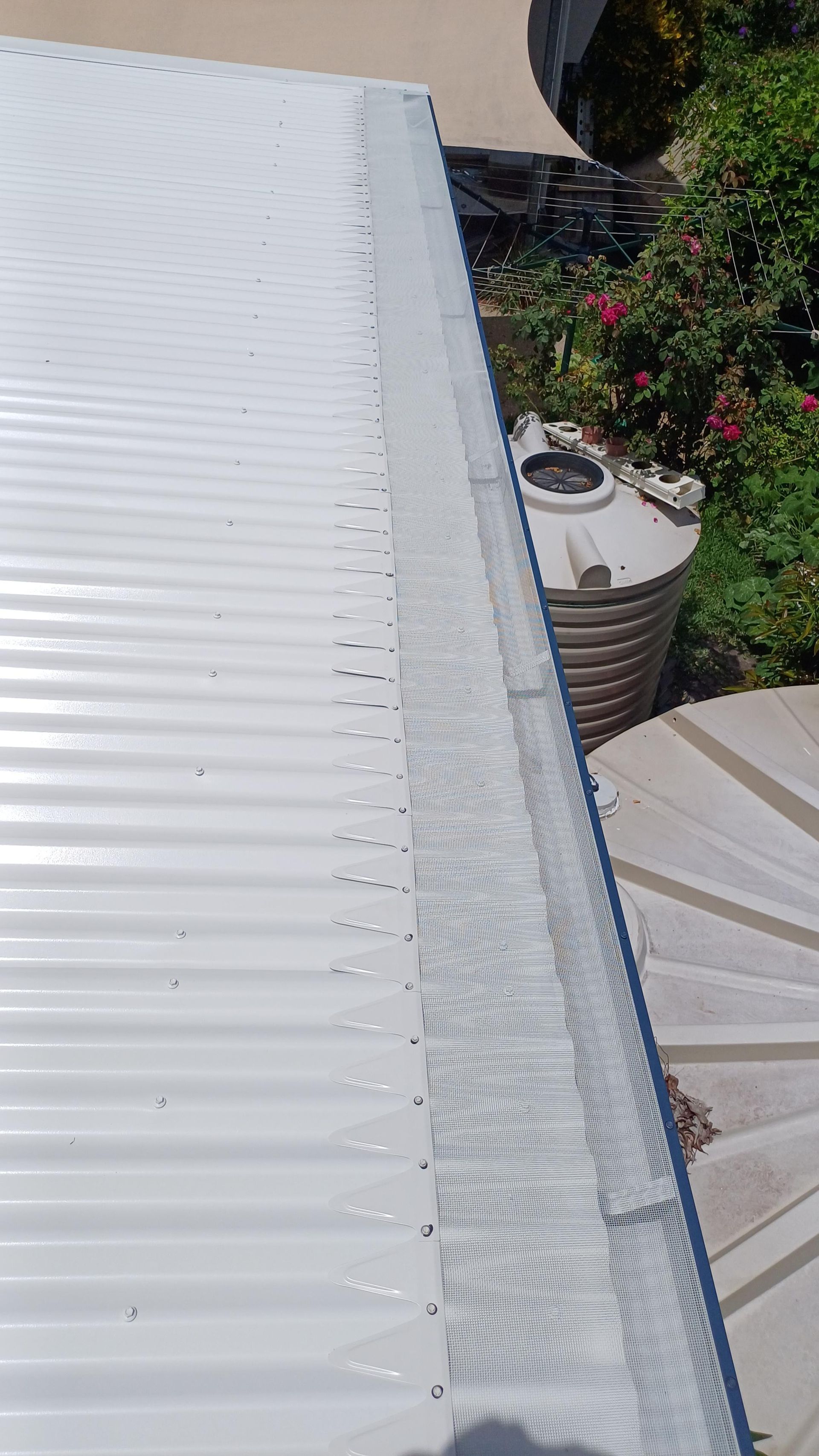A White Corrugated Metal Roof With A Gutter On It — Rooftech Roofing Services in Northern Rivers, NSW
