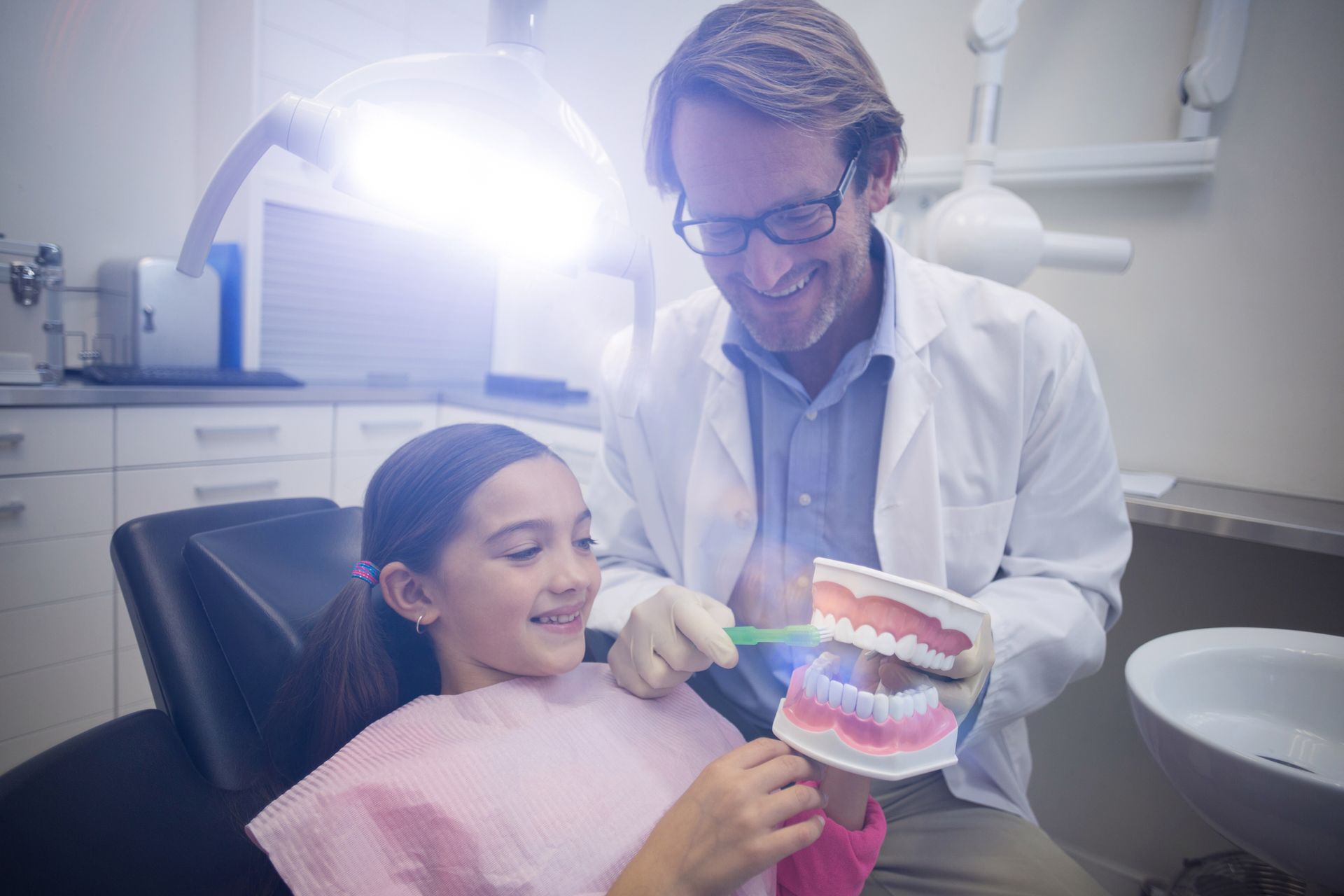 Dentist teaches girl brushing