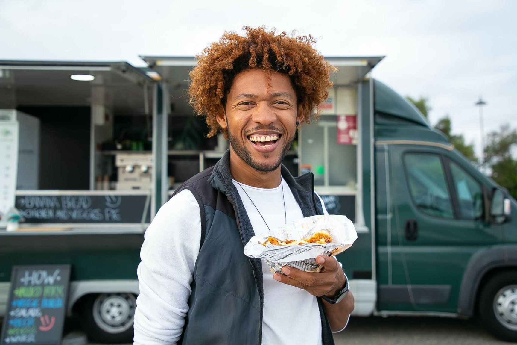 Man with food by food truck 
