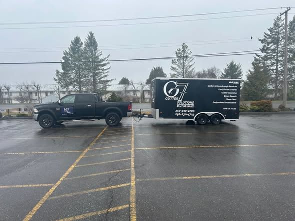 Black truck towing a black trailer in a parking lot. Trailer has company logo, 