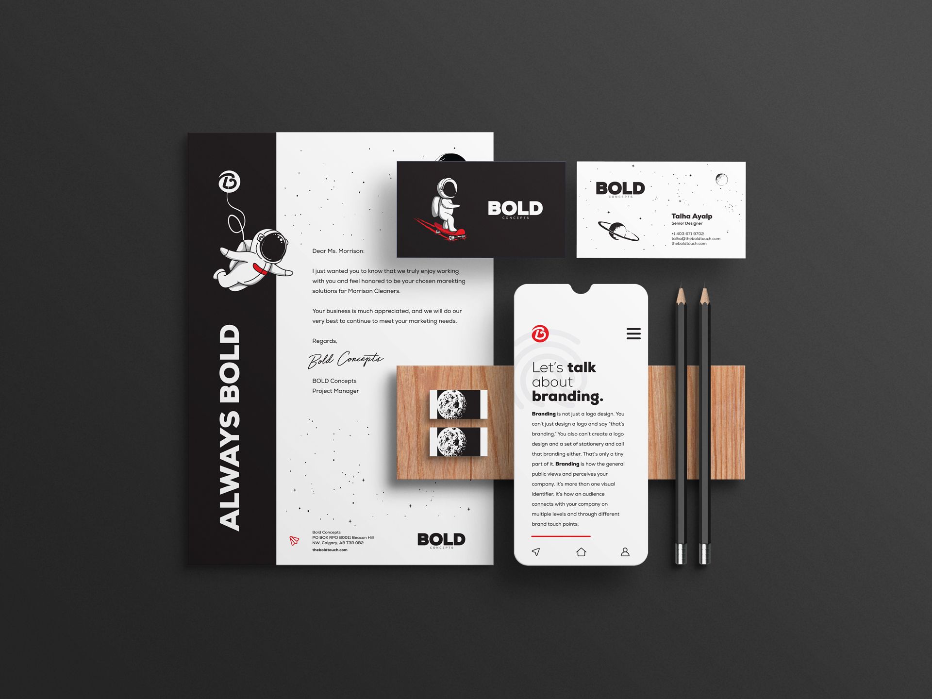 A mockup of a business card , letterhead , phone , and pencils.