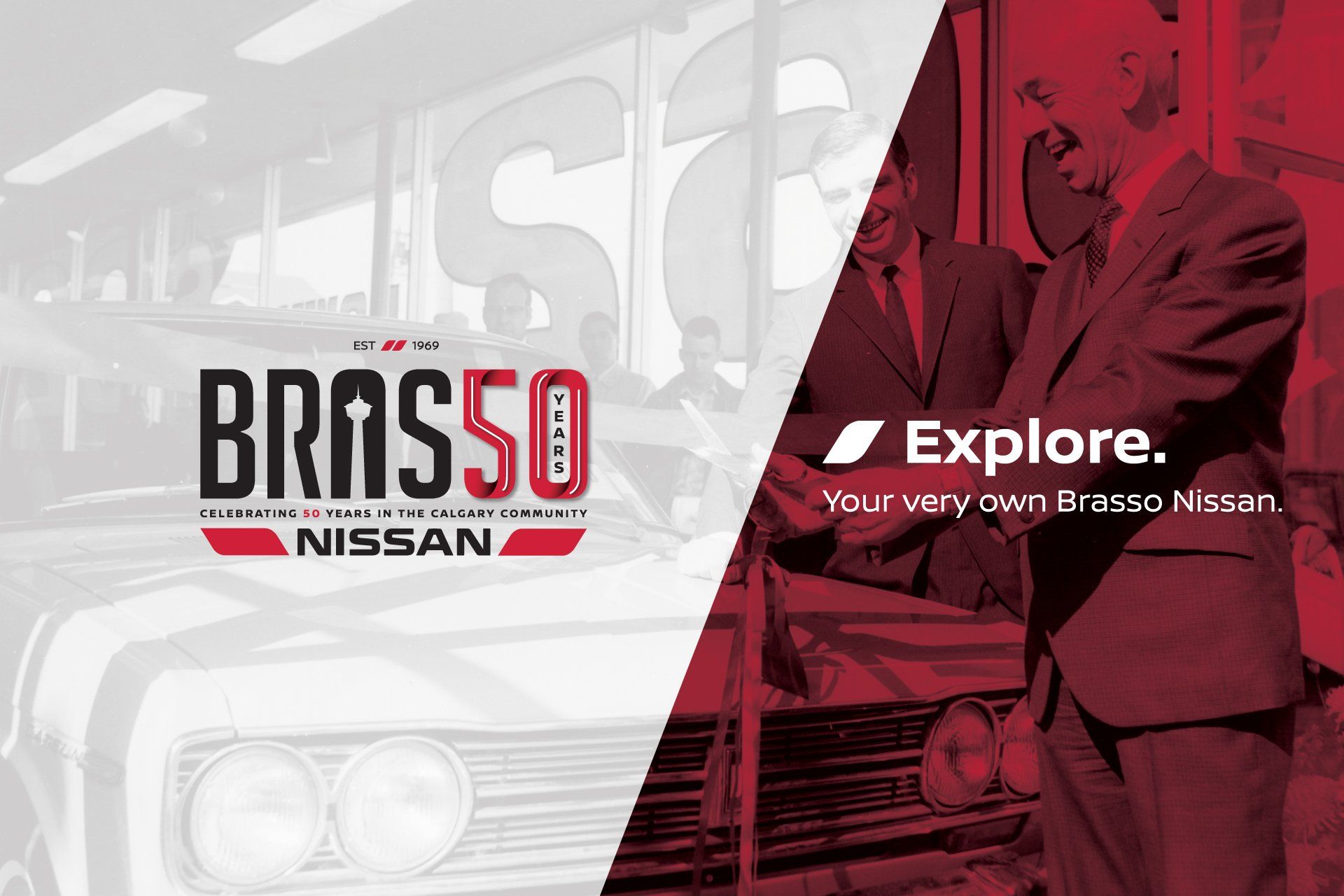 A man in a suit is talking on a cell phone next to a nissan car.