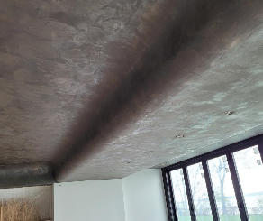 Two workers installing a large white ceiling panel in an unfinished room