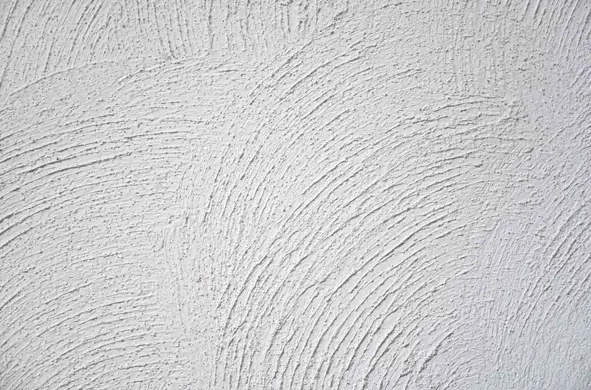 White textured wall with a long horizontal crack and a vertical diagonal crack branching downward