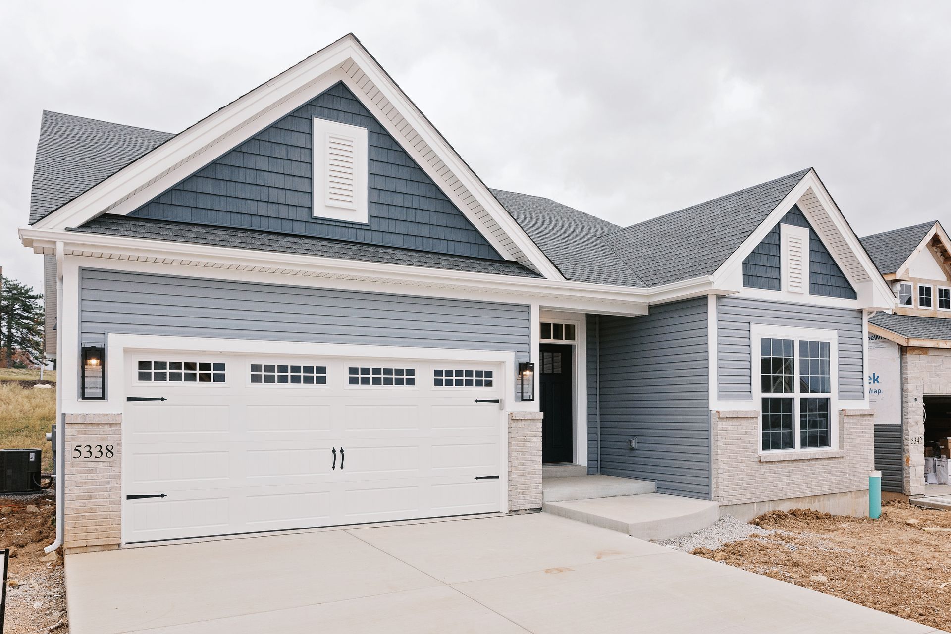 Exterior of the Dean Martin model with a two-car garage, stone accents, and a front walkway.
