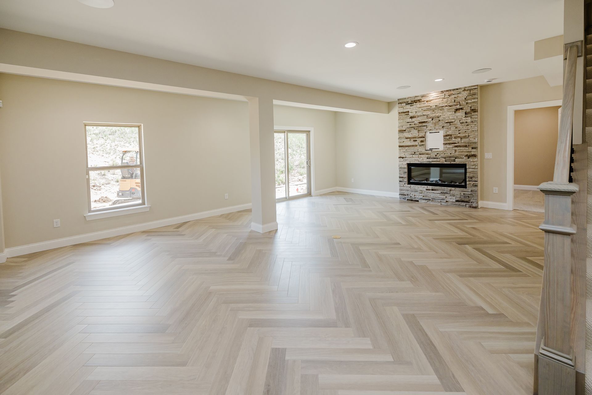 Spacious interior of the Humphrey Bogart modelwith herringbone wood floor, fireplace, and sliding doors.