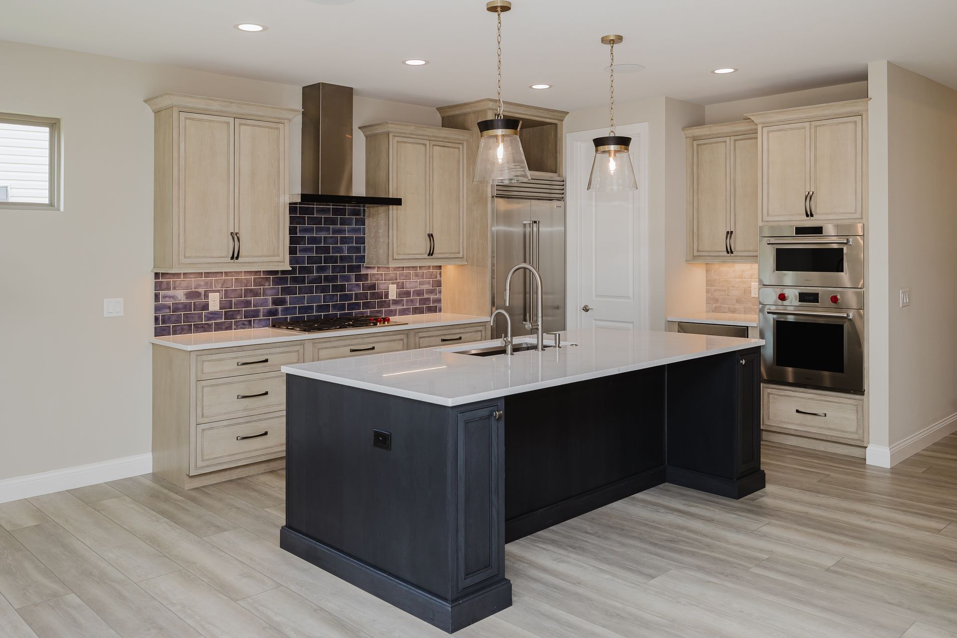 Modern kitchen of the Humphrey Bogart model with a black island, white countertops, and light-colored cabinets.