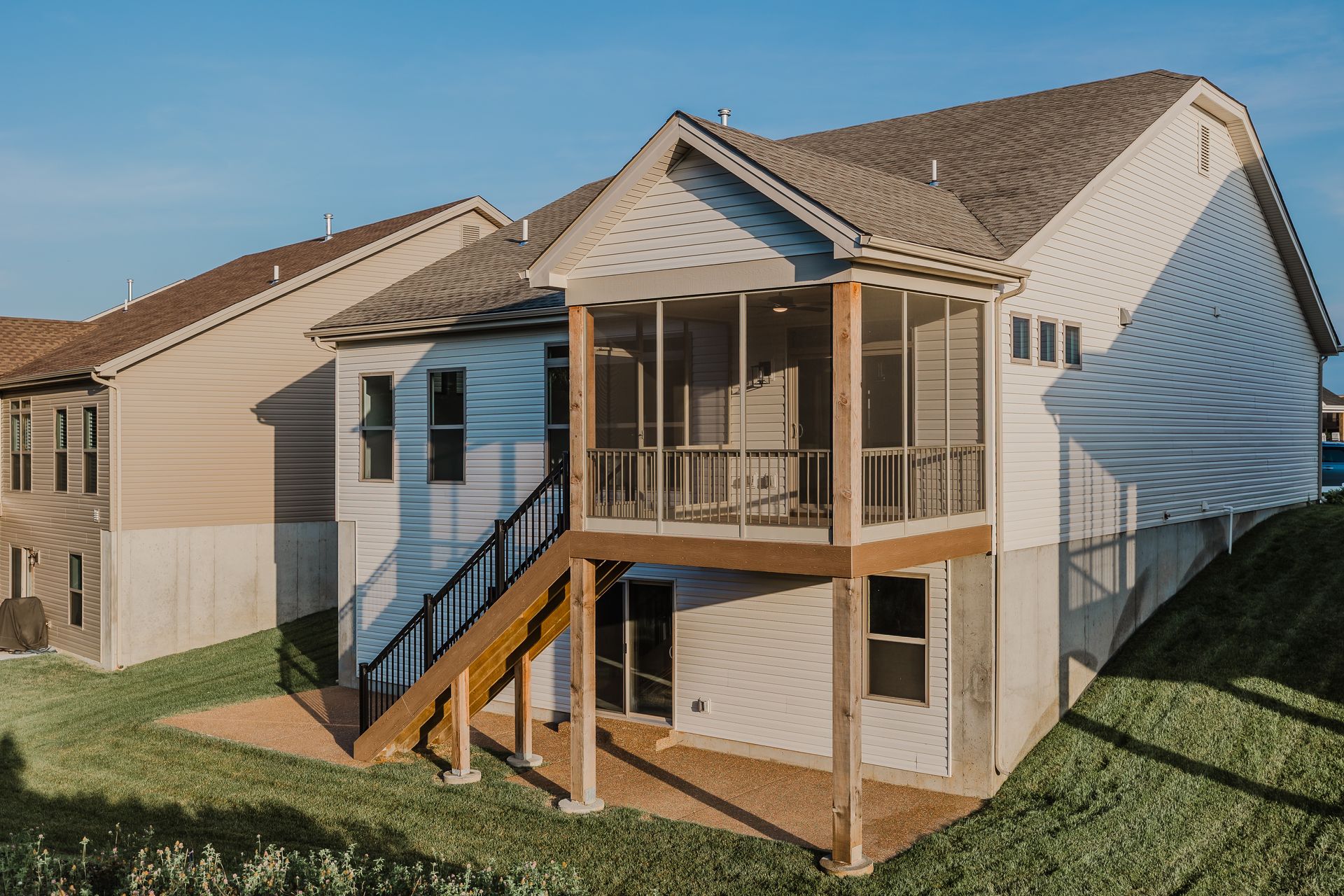 Marilyn Monroe model exterior with a screened porch, wooden deck, and concrete foundation against a blue sky.