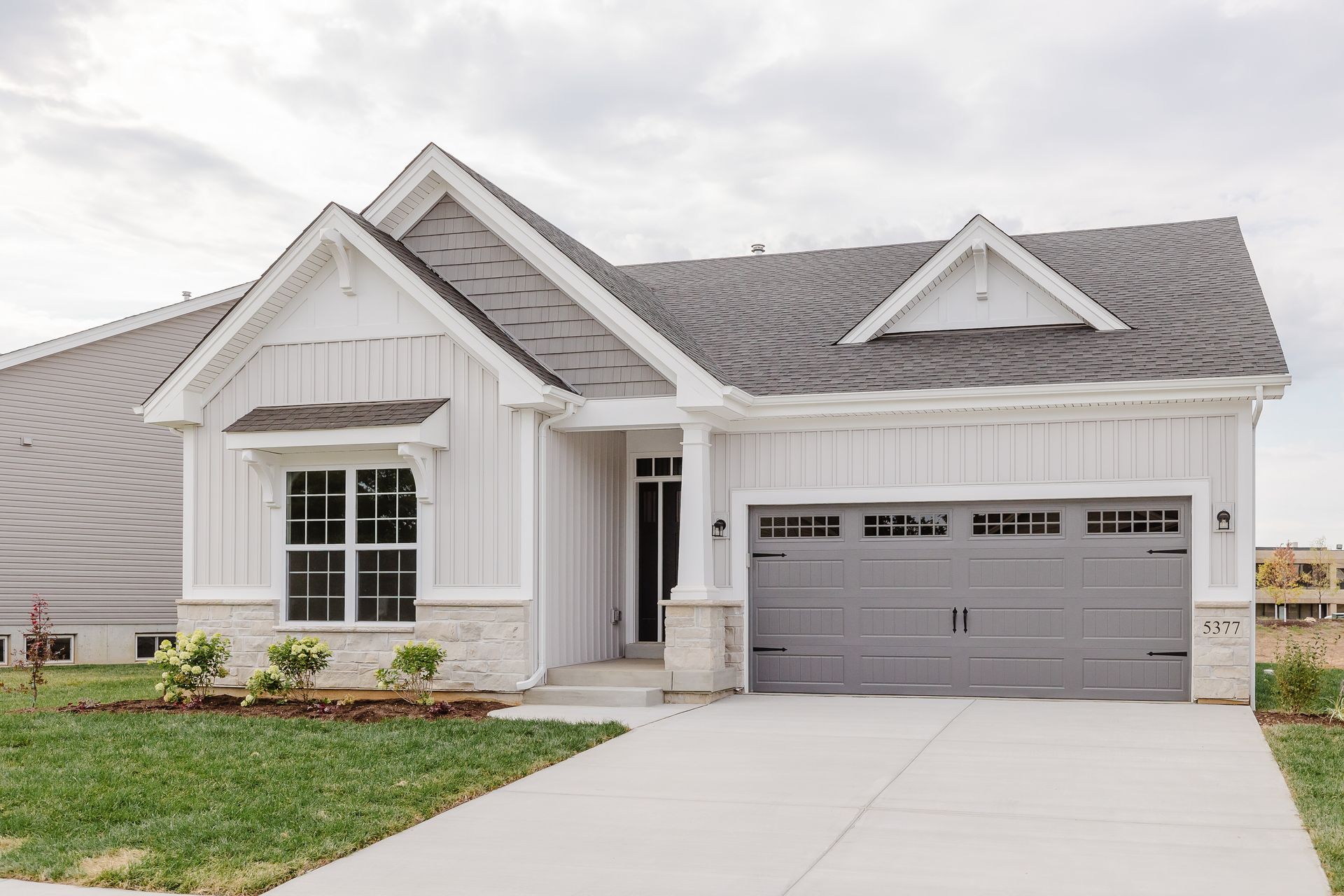 Exterior of the Cary Grant model with gray roof and garage door; driveway and lawn in front.