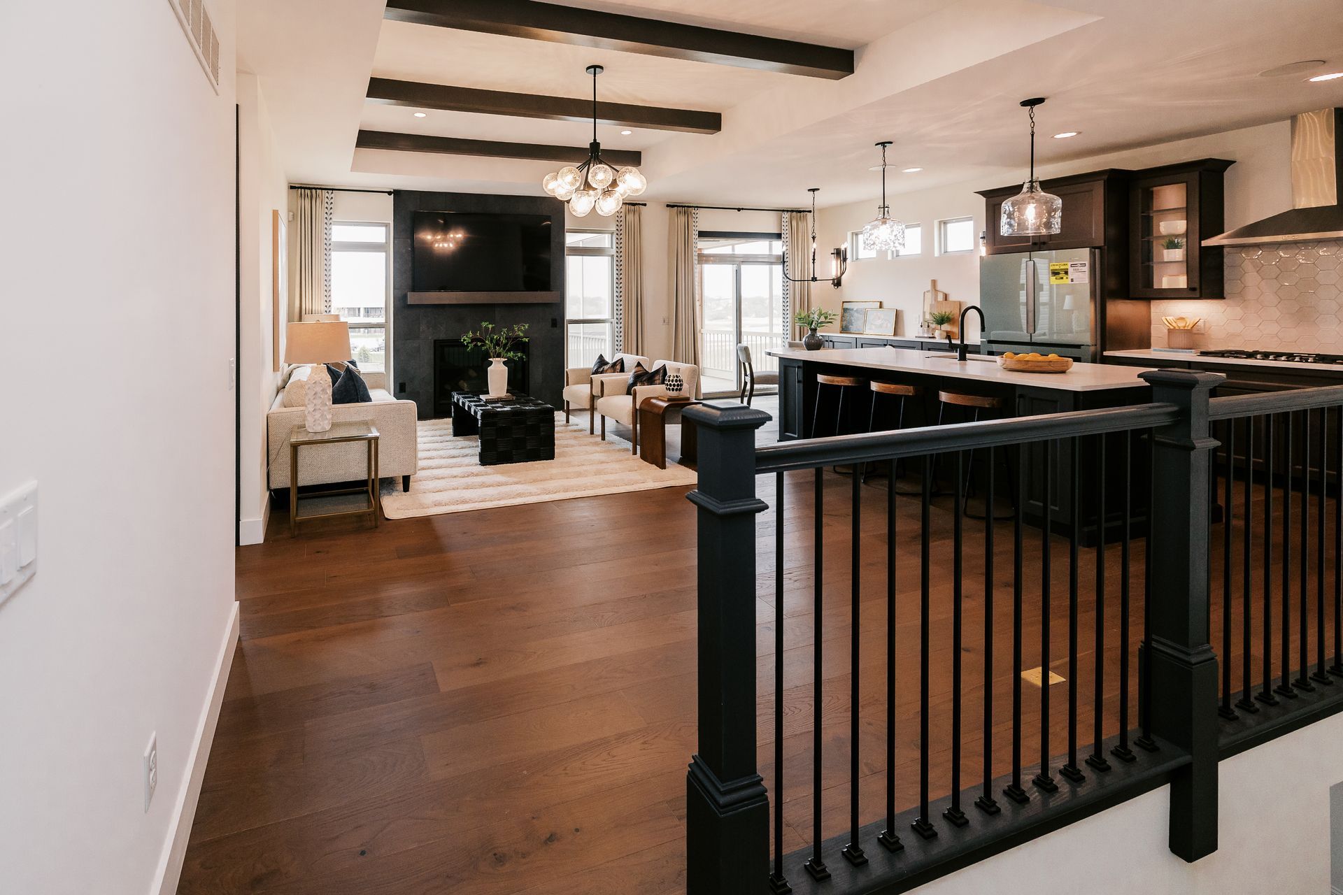 Open-concept living space in the Cary Grant model with hardwood floors, dark accents, and a kitchen island.