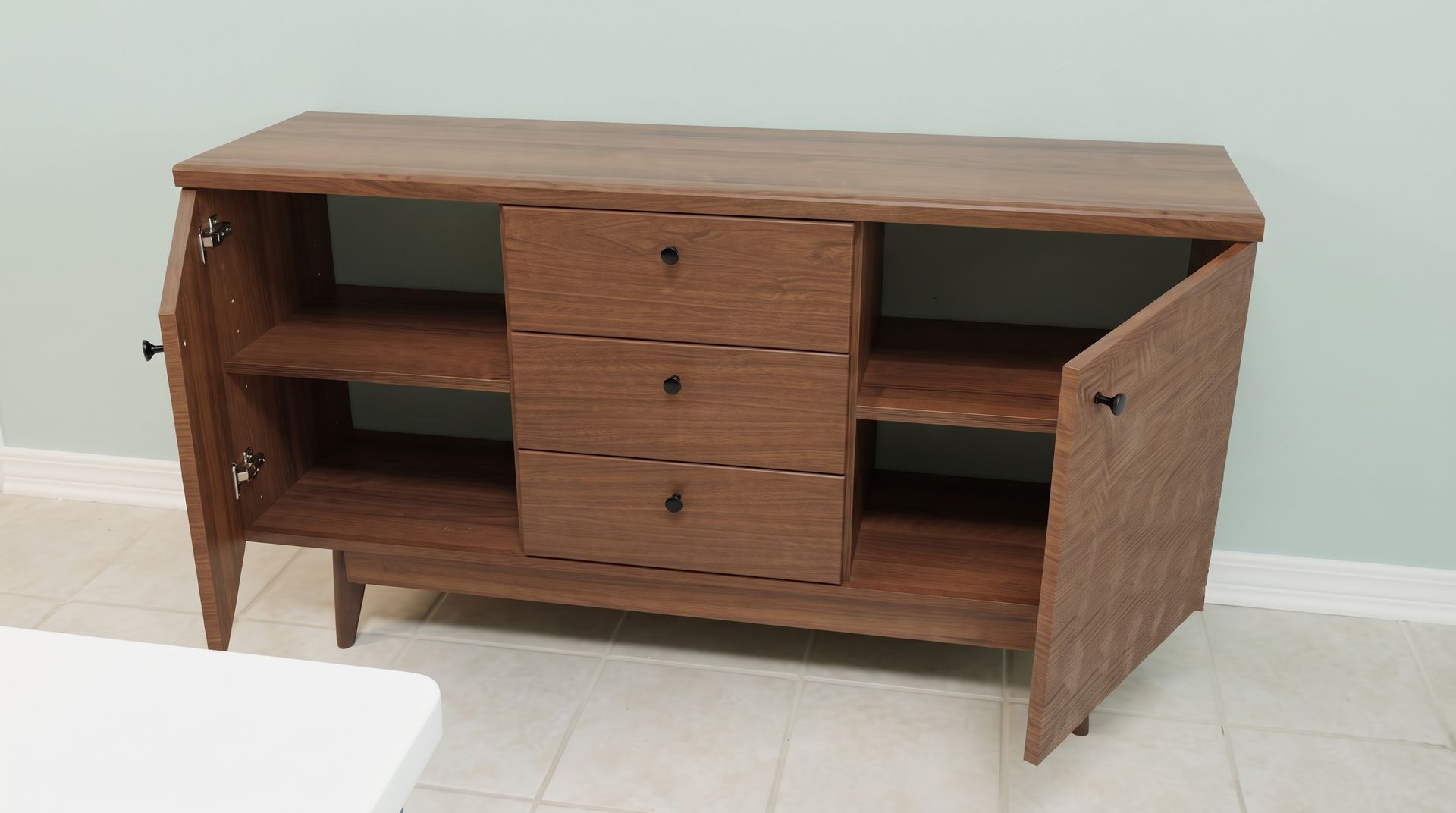 Wooden sideboard with open shelves and center drawers against a light wall, one door open.
