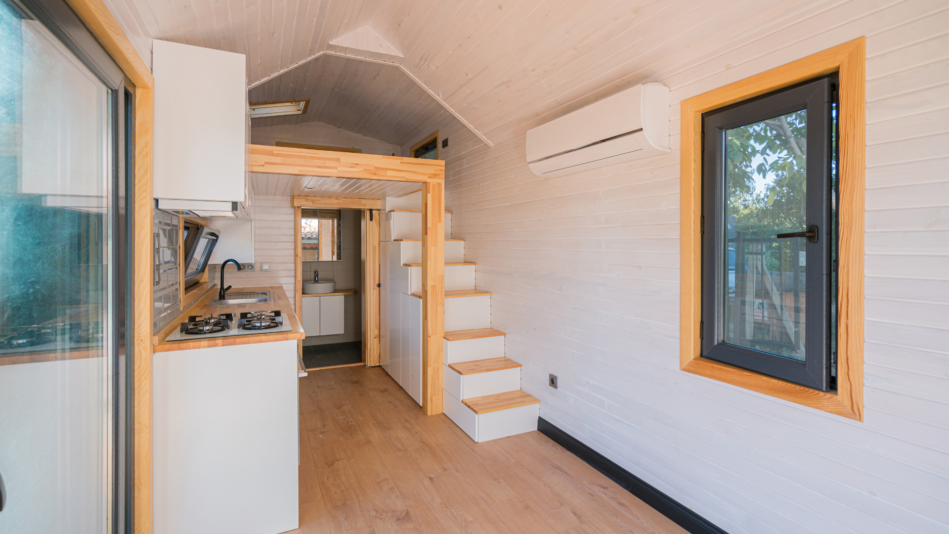 A small house with stairs leading up to the second floor and a kitchen.