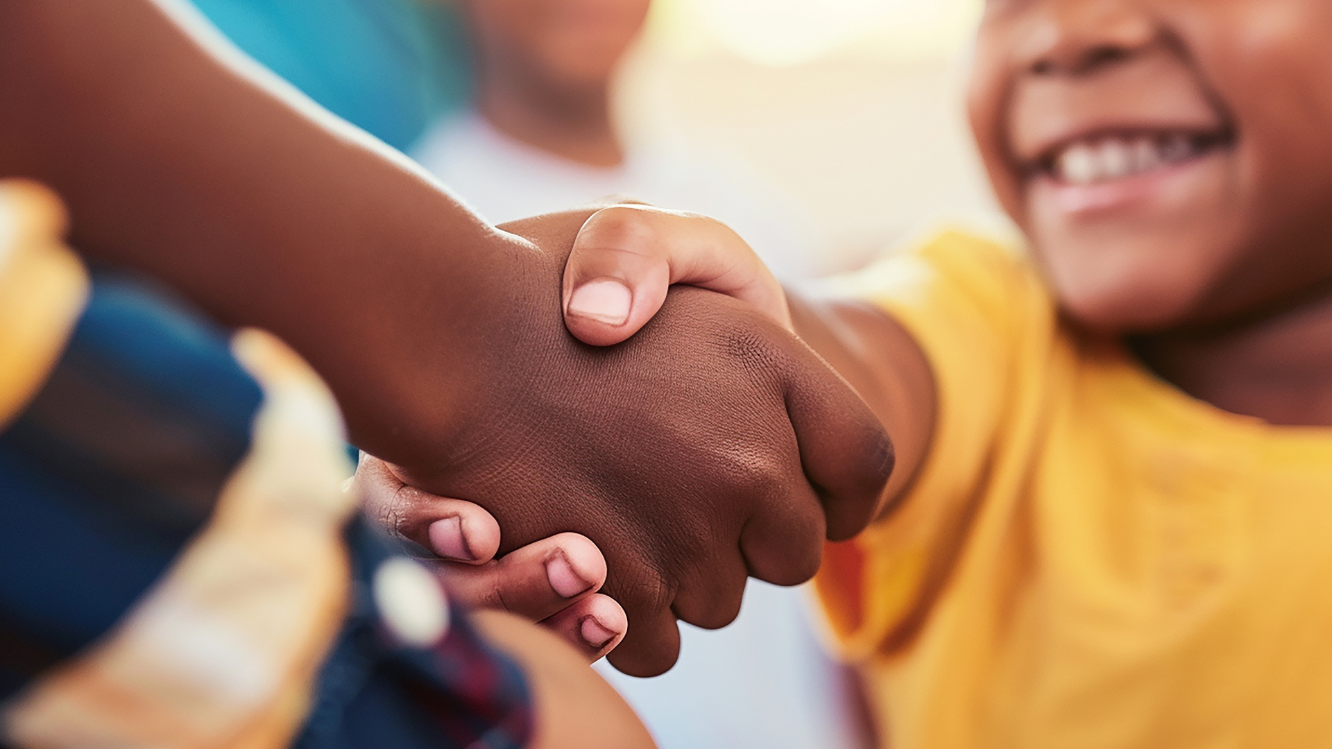A group of children are shaking hands with each other.