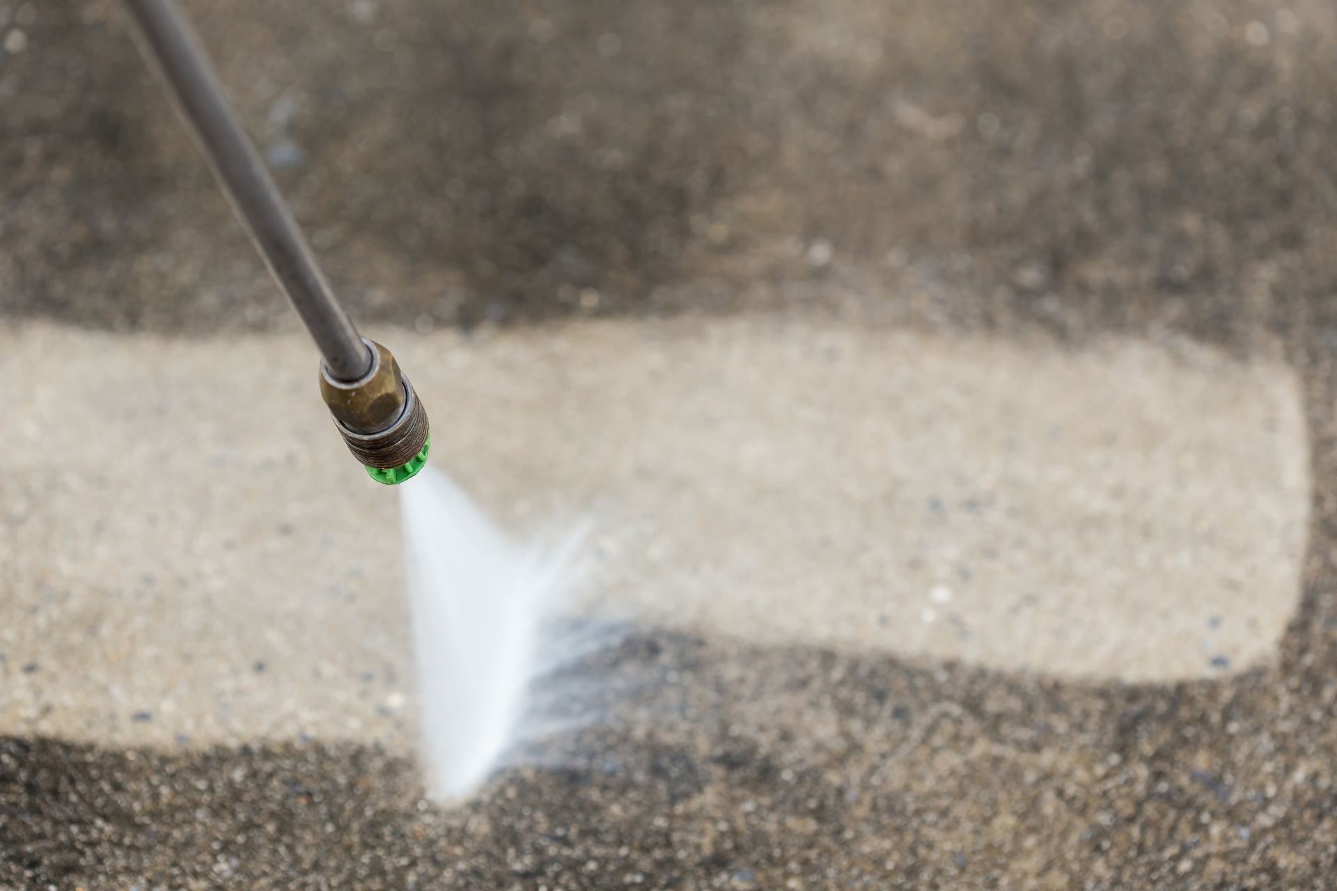 Pressure washer spraying water on a concrete surface