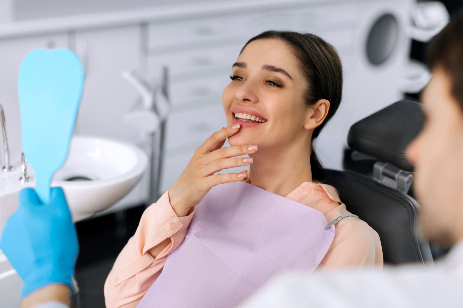 Dental services patient smiling after treatment while reviewing results with dentist. Dental services patient smiling after treatment while reviewing results with dentist.