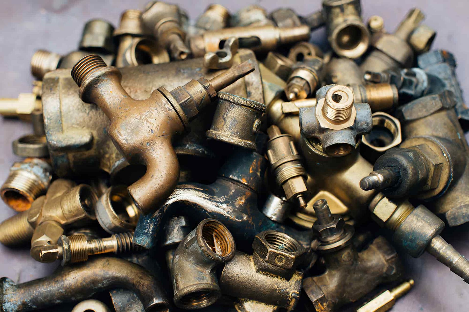 A Pile Of Brass Pipes And Fittings On A Table — North Queensland Recycling Agents In Bungalow, QLD