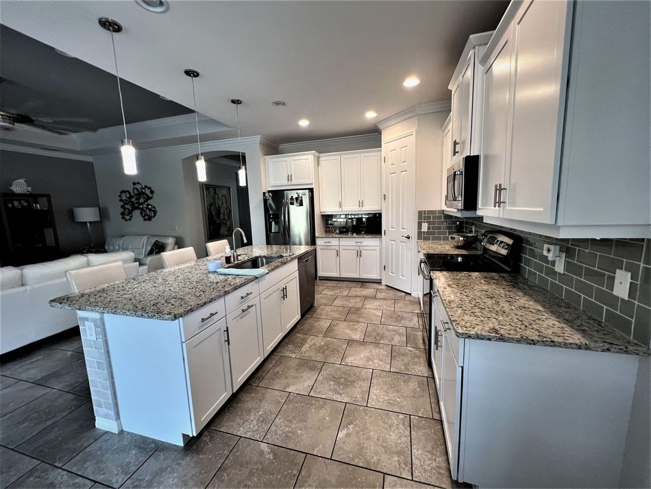 a kitchen with granite counter tops and white cabinets