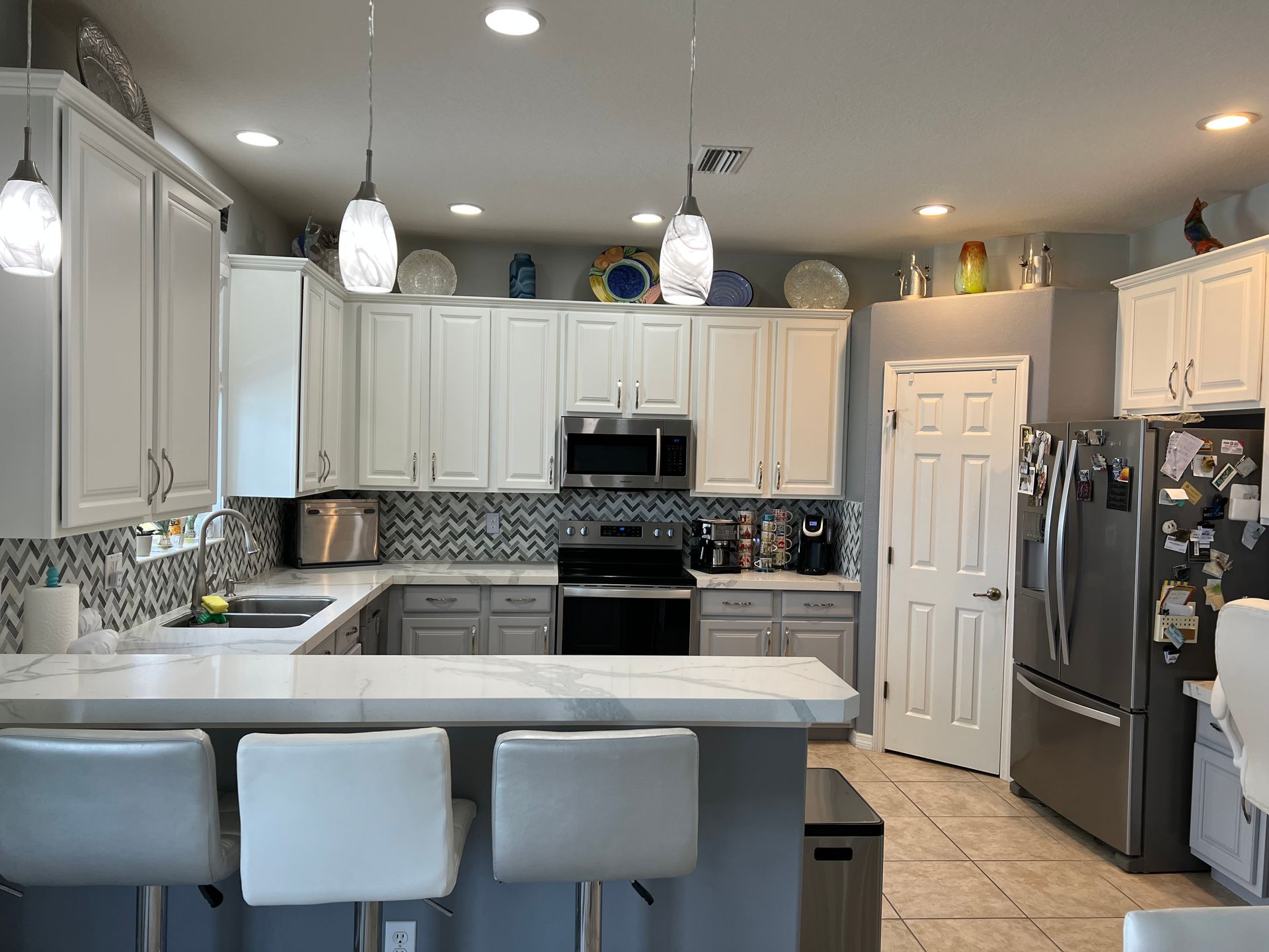 a kitchen with white cabinets and stainless steel appliances