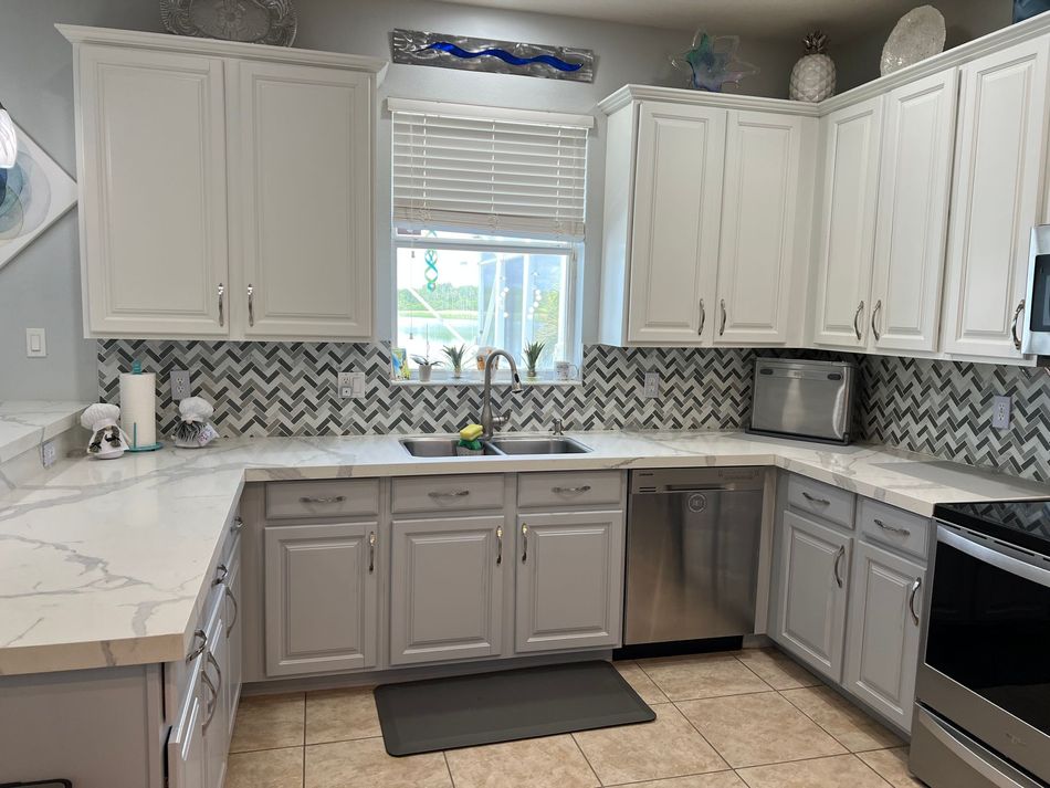 a kitchen with white cabinets and stainless steel appliances