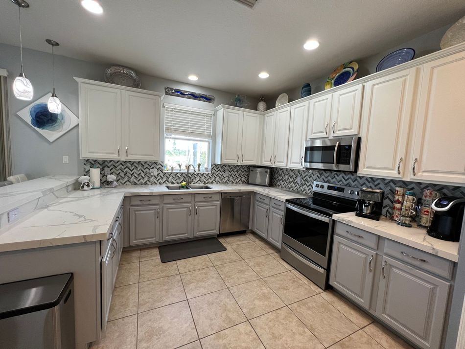 a kitchen with white cabinets and stainless steel appliances