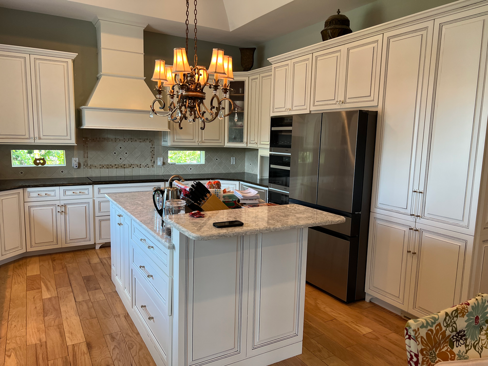 a kitchen with white cabinets and a stainless steel refrigerator