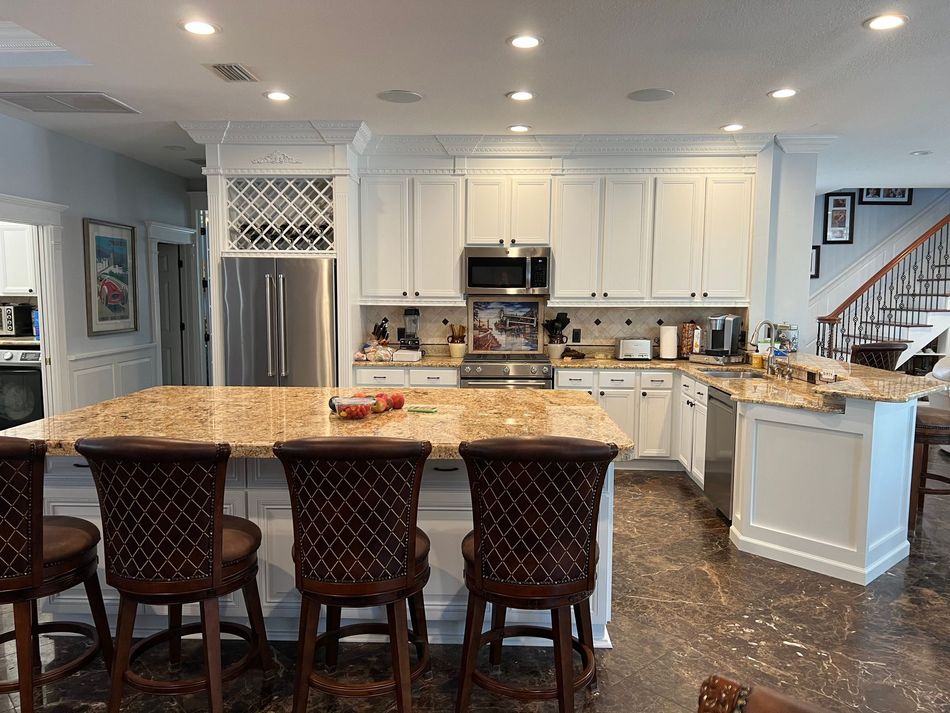 a kitchen with white cabinets and stainless steel appliances
