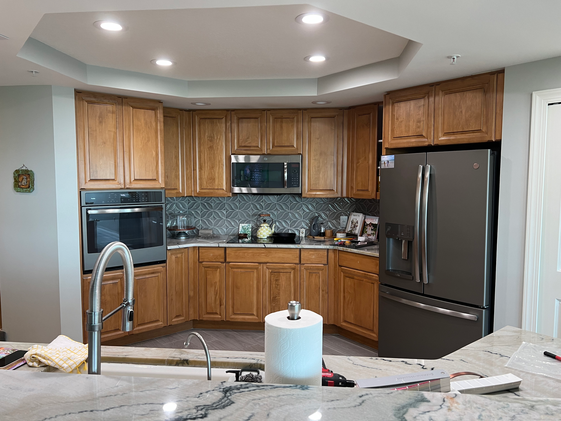 a kitchen with wooden cabinets and a stainless steel refrigerator