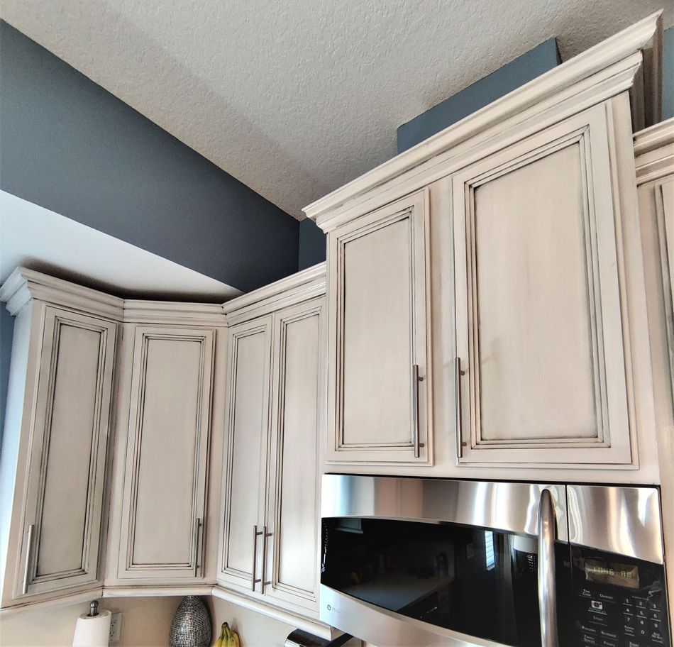 a kitchen with white cabinets and a stainless steel microwave