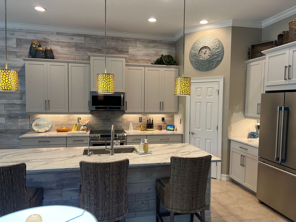 a kitchen with white cabinets and a clock on the wall