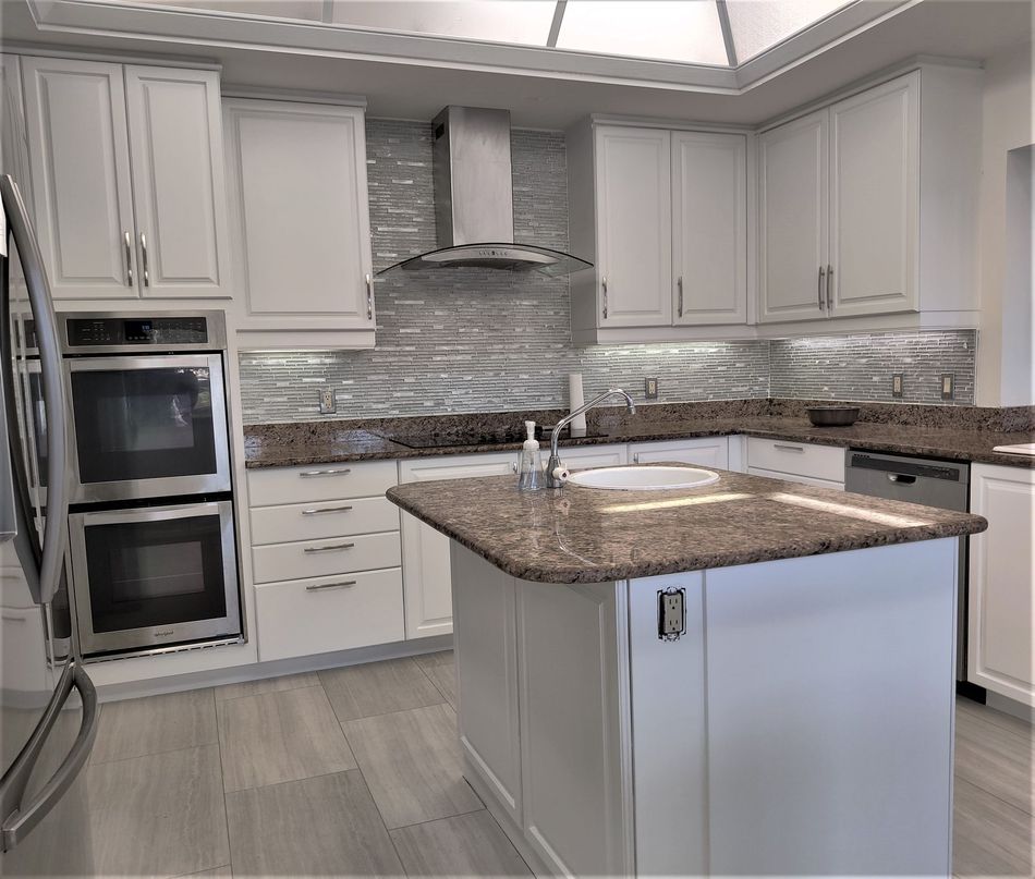 a kitchen with white cabinets and stainless steel appliances