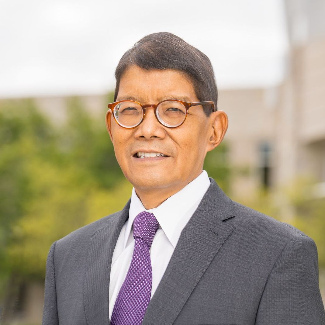 A man in a suit and tie is smiling for the camera.