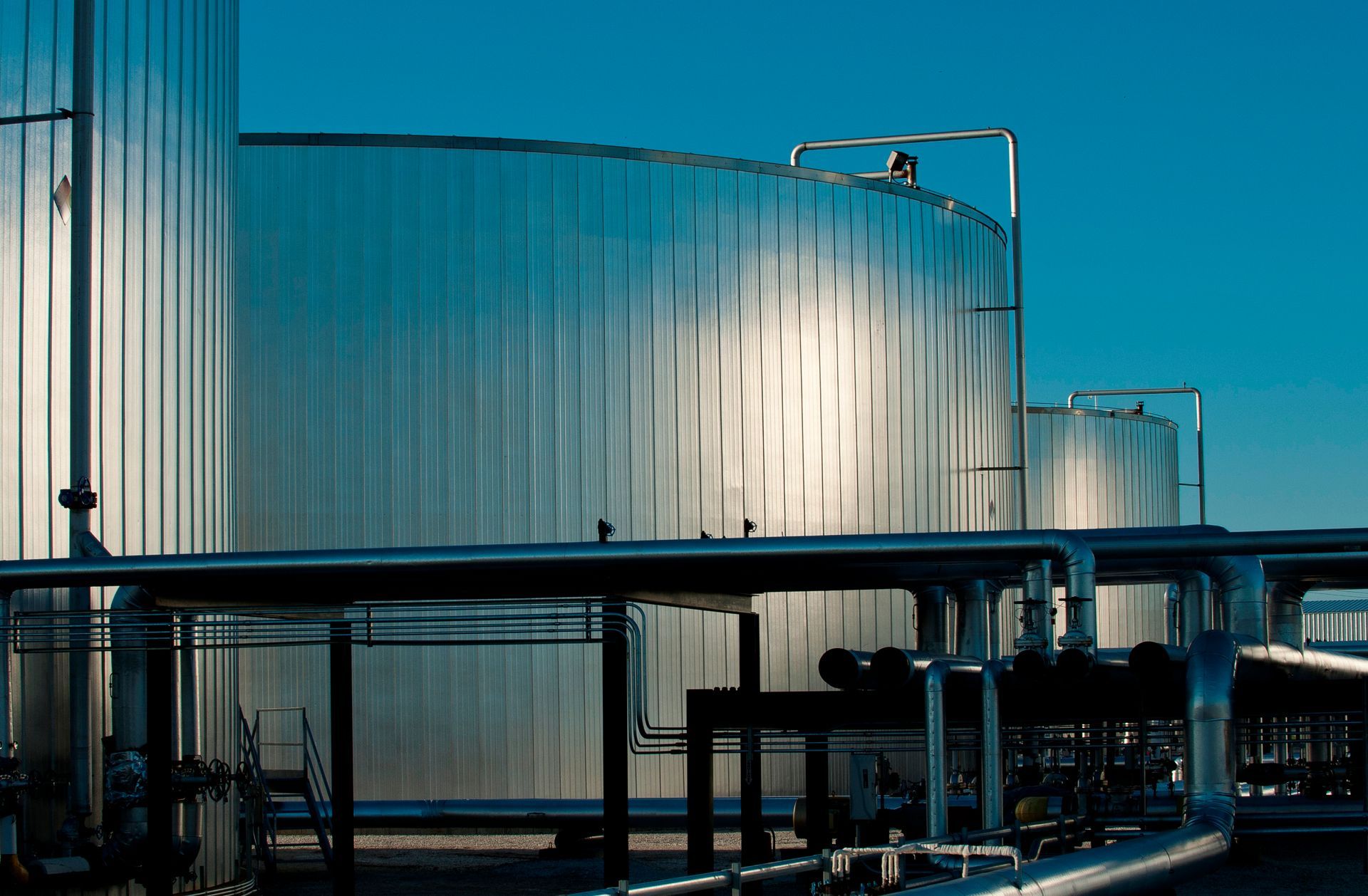 A row of large tanks are lined up in a factory