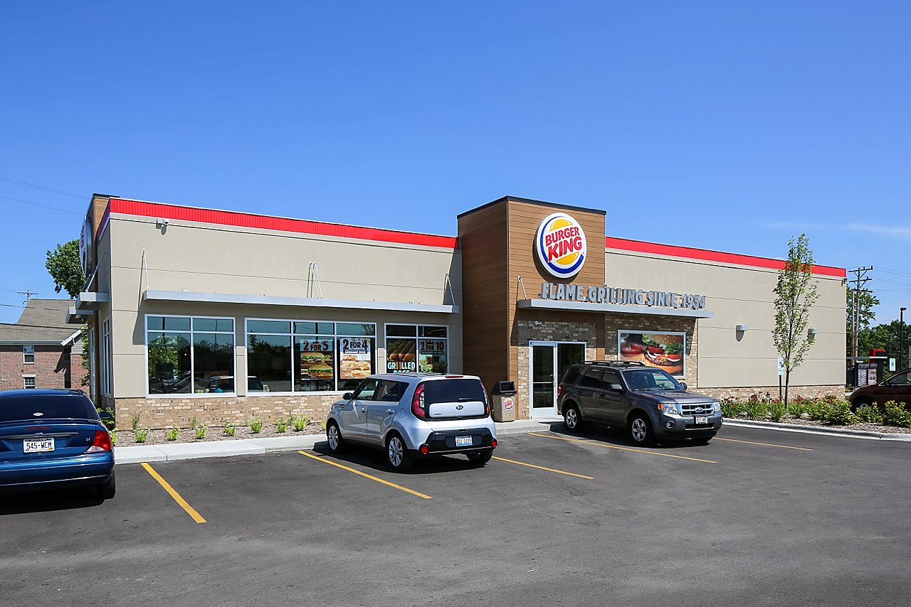 A burger king restaurant with cars parked in front of it