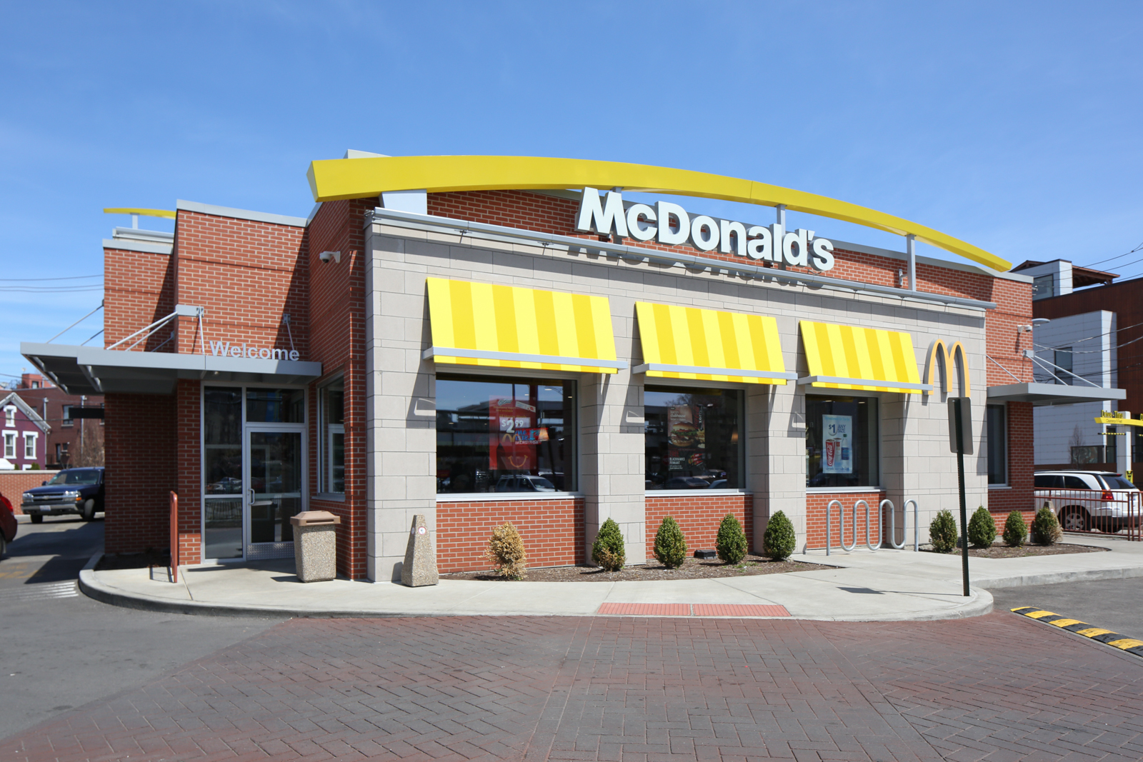 A mcdonald 's restaurant with yellow awnings on the windows