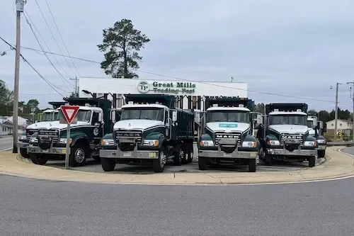 GMTP dump truck fleet lineup on job site