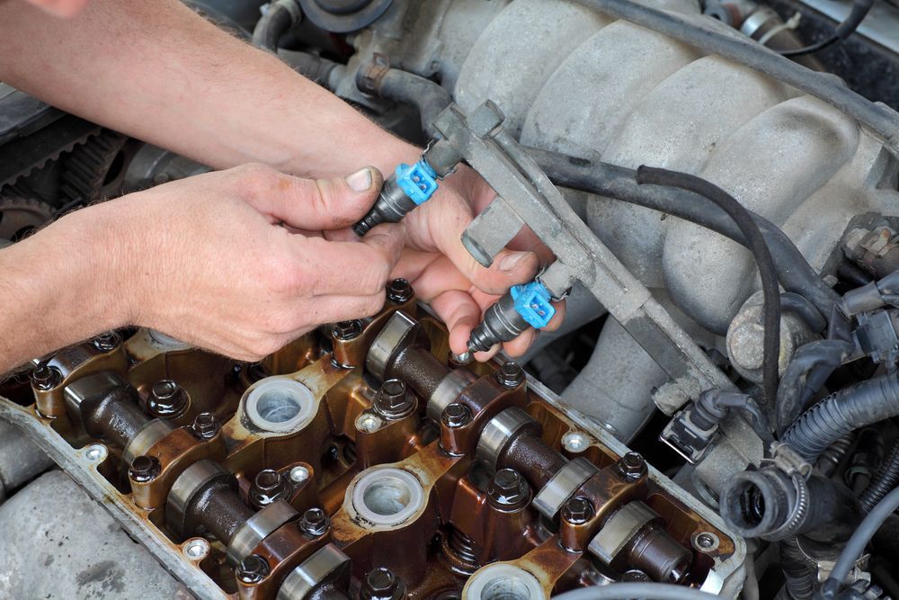 A Man is Working on the Engine of a Car — Allan Ross Mechanical Repairs in Charmhaven, NSW