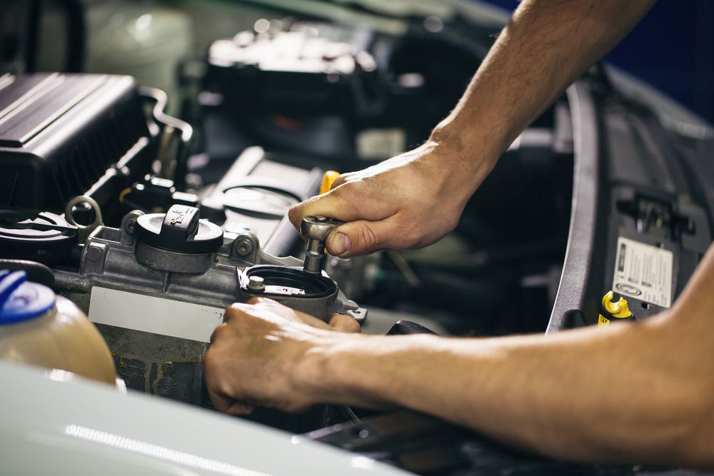 A Man is Working on the Engine of a Car — Allan Ross Mechanical Repairs in Charmhaven, NSW