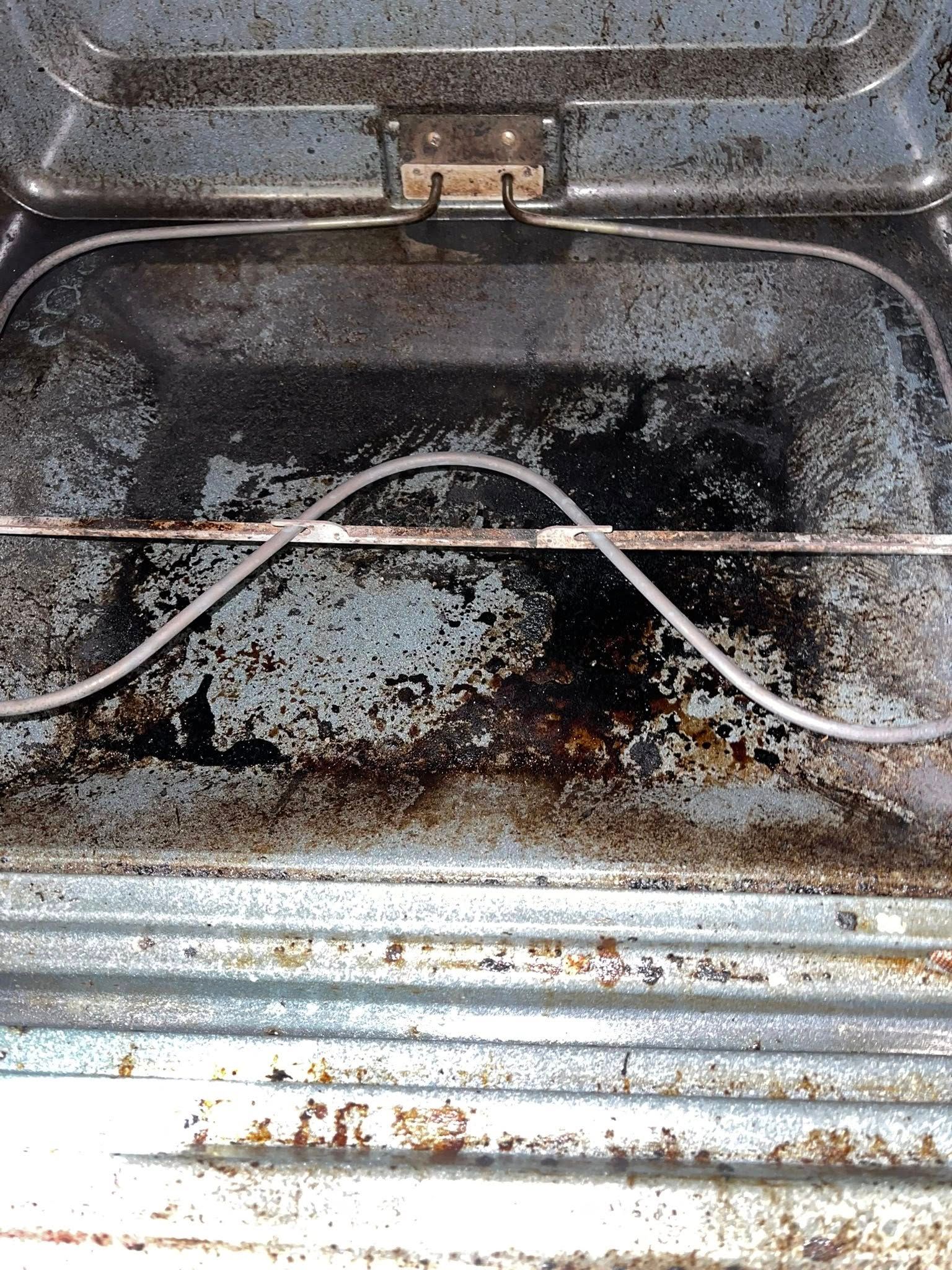 Dirty oven interior with visible food residue and heating element.